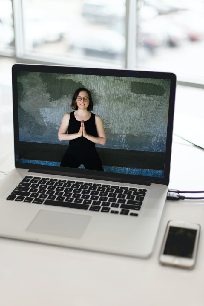 Patricia Windt, Inhaberin von BRIGHT YOGA, zu sehen auf einem Laptop-Bildschirm in einer Yogapose